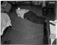 Euclide Allard, 66, demonstrating how he was tied up by a burglar on his hotel room floor and robbed of $6950, Los Angeles, February 16, 1940