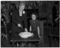 Mrs. Paxton Lytle and Mrs. J.M. Hughes cut a cake during a women's club meeting, Los Angeles, 1930s