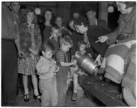Children getting something to drink in the S.R.A.'s Vermont District office while pickets gathered outside to protest a cut in relief checks, Los Angeles, February 28, 1940
