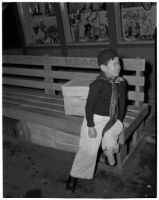 Young boy sits on a bench in Chinatown, Los Angeles, 1930s