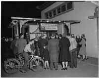 Crowd gathers around Charlie Chan, fortune teller, in Chinatown, Los Angeles, 1930s