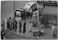 Aerial view of pedestrians and Owl Drug on the corner of Hollywood and Vine, Los Angeles, 1940
