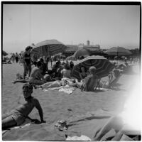 Group sits under umbrellas on a crowded beach on Labor Day, Los Angeles, September 3, 1945