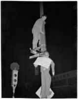 Man removes a dummy hanging from the Hollywood and Vine street signs, Los Angeles, May 4, 1946