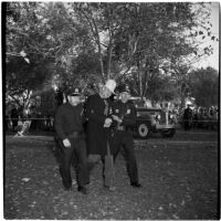 Anaheim Chamber of Commerce secretary-manager Ernest W. Moeller with two unidentified policemen on Halloween, Anaheim, October 31, 1946