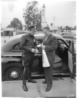 Dick Russell signing the speeding ticket he received from police officer Dick Barlow during a planned race to demonstrate the importance of following traffic laws, Los Angeles, 1947