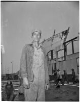 Man standing in front of the wreckage of Berth 153, a terminal in L.A. Harbor that was destroyed when the Markay oil tanker exploded, Los Angeles, 1947