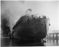 Ship amid smoke rising from the Markay oil tanker explosion in L.A. Harbor, Los Angeles, 1947