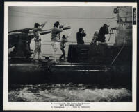 Cast members firing rifles atop a surfaced submarine in Hell and High Water