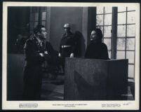 Ray Milland, Florence Marly and extras in a scene from Sealed Verdict