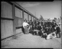 UCLA football coach William Spaulding reviews game strategy with team at Spaulding Field, Los Angeles, 1930s