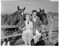 Mary Pickford and Buddy Rogers posing with horses at a ranch, Los Angeles, 1936