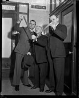 Patrick J. McManus examining a piece of film with Detective Lieutenants Joe Filkas and William Baker, Los Angeles, 1937