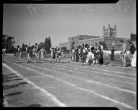 Track athletes pass batons in a relay event during the All-City High School track and field meet, Los Angeles, 1937