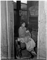 Poverty-stricken woman and child pictured inside a dilapidated dwelling, Los Angeles, 1930s