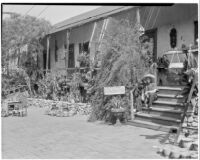 Avila Adobe, front view of porch with man seated on steps, Olvera Street, Los Angeles, 1934