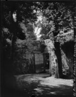 Gardens at the Alhambra, view of a shaded walkway leading to a door in a garden wall, Granada, Spain, 1929