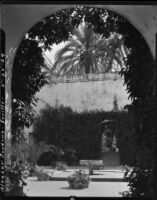 Gardens at Alcázar of Seville, view through an arch into a courtyard, Seville, Spain, 1929