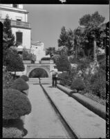 Gardens at Casa del Rey Moro, view of a gardener standing in front of a concave fountain, Ronda, Spain, 1929