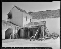 Agricultural equipment leaning against a roof, La Penucla Granja, Spain, 1929