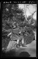 Rosita Dee Cornell sitting on a tree stump, California, 1933