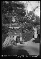 Rosita Dee Cornell sitting on a tree stump, California, 1933