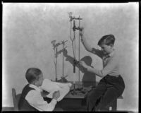 Two school boys at Thomas Starr King Junior High School demonstrate a science experiment, Los Angeles, circa 1933