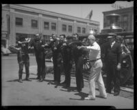 Dr. St. Louis Albert Estes and uniformed men exercising (?) on street corner, between 1933 and 1936