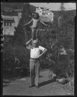 Dr. St. Louis Albert Estes and child outdoors, [Van Nuys?], between 1928 and 1936