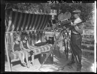Two Estes children on glider swing posing for cameraman, [Van Nuys?], between 1928 and 1936
