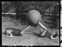 Two Estes children playing with exercise ball in a yard, [Van Nuys?], between 1928 and 1936
