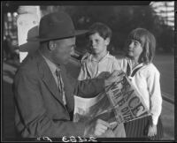 Veteran Leonard L. Deaver and two children with newspaper, Los Angeles, 1928 or 1930