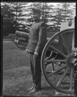 Veteran Robert W. Renton, in uniform with medals, standing in front of row of cannons, Los Angeles, 1928 or 1930
