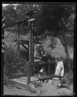 Woman and girl with water pump, near Saddle Peak, Los Angeles, 1929