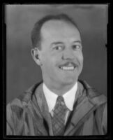 Portrait of Darrel B. Foss, smiling in suit, tie, and striped overcoat, 1924