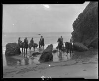Men on horseback on beach