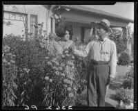 Eugene R. Plummer and woman in flower garden at his home, West Hollywood, 1927