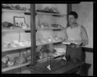 Los Angeles City College student with shelves of rocks and minerals, Los Angeles, circa 1933-1938