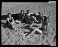 Los Angeles City College students on beach with surfboard, circa 1933-1938