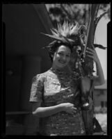 Los Angeles City College student with bird of paradise plant, Los Angeles, circa 1933-1938