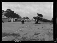 Biplane and men at airfield, [1920s?]