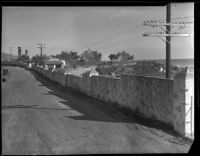Wall, house, and cars, Malibu, 1929