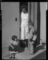 Children and woman on porch with suitcases, Los Angeles, circa 1935