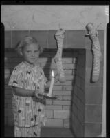 Girl with candle and Christmas stockings, Los Angeles, circa 1935