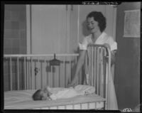 Nurse with baby in crib, Los Angeles, circa 1935