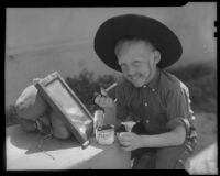 Boy painting beard and mustache on himself, Los Angeles, circa 1935