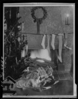 Montage photograph of Mawby triplets in front of fireplace with Christmas tree and stockings, [Santa Monica, 1929]