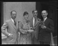 Three men and one woman posing with flowers and military-style hat, 1936