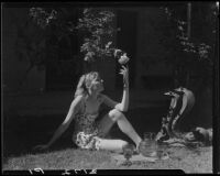 Mrs. Jack Pfister reaching for a rose, Palm Springs