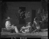 R. Lee Miller reading to Mrs. Jack Pfister and A. Boyd Mewborn in his patio, Palm Springs